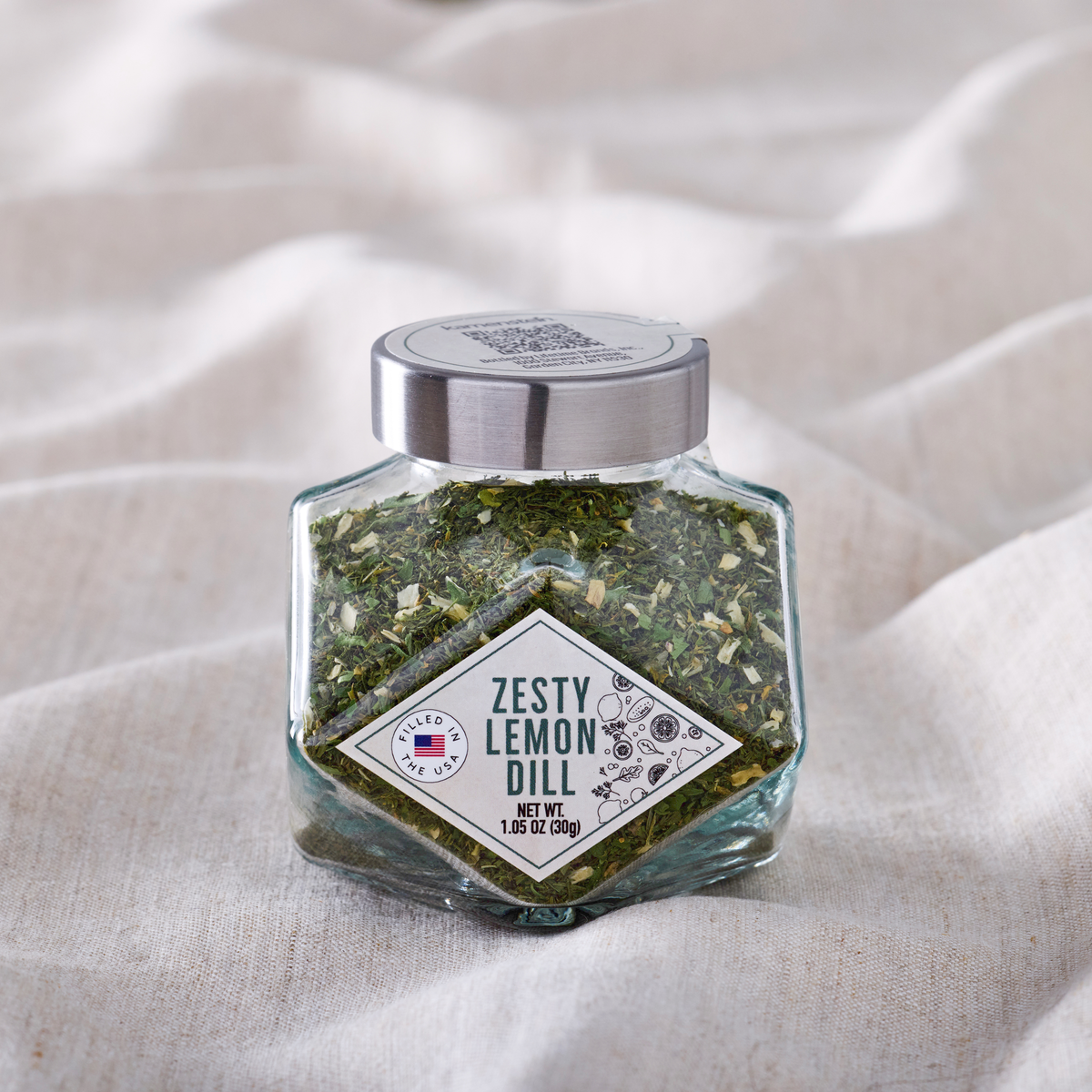 Diamond jar of Zesty Lemon Dill seasoning with a silver cap and visible dried herb flakes